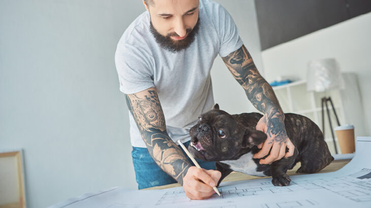 Hombre sosteniendo un plano con un perro